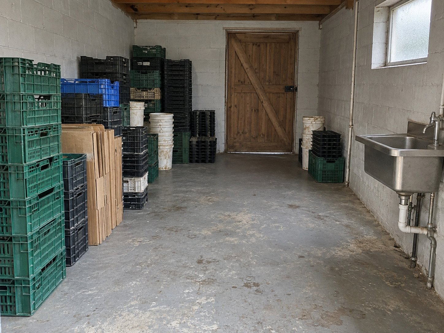 Empty produce crates, pails and packaging awaiting hauling from a farm packing room.
