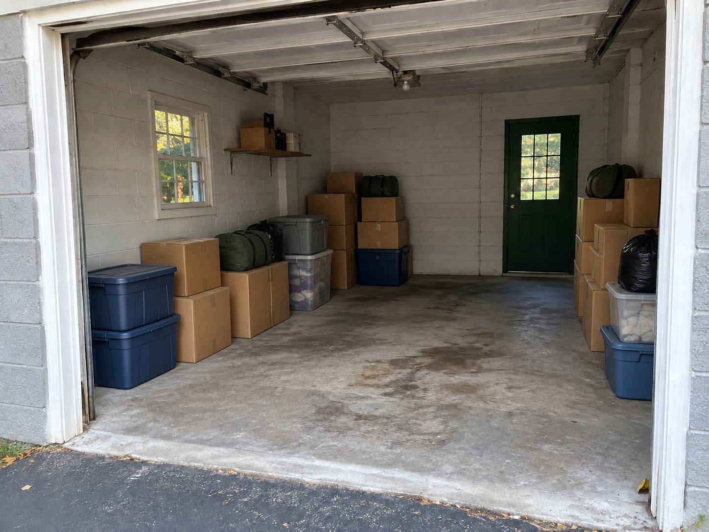 Boxes and totes in a masonry garage before contents cleanout.
