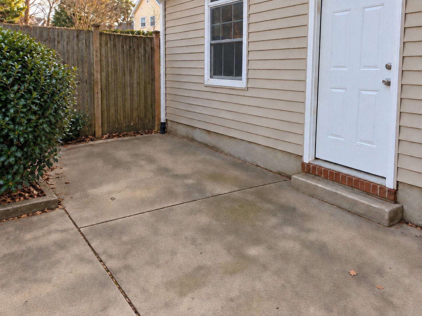 Existing concrete apron clear of construction debris beside a house.