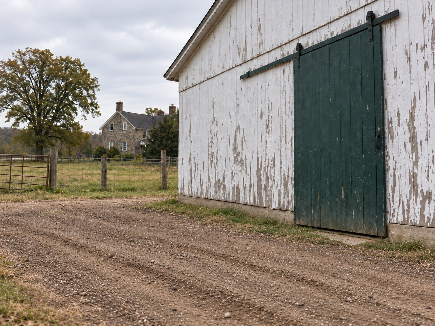 Clear farm staging area beside an old barn after hauling away stored materials.