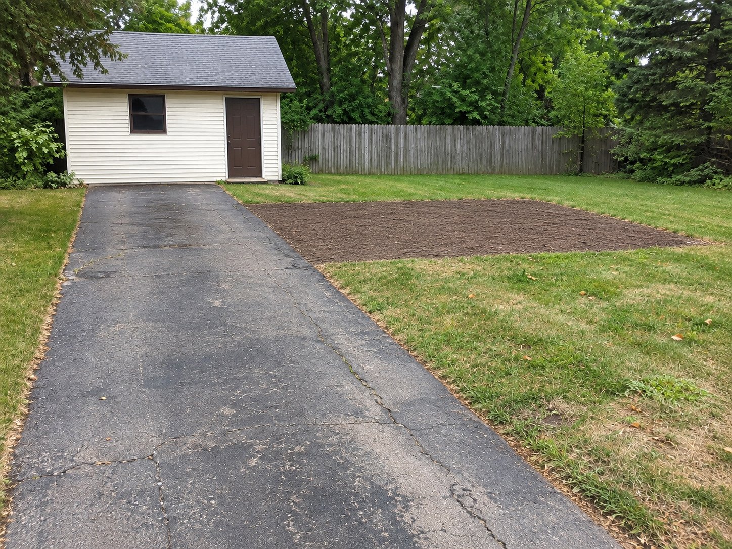 Soil footprint after the side parking spur was removed, with the main asphalt approach retained.