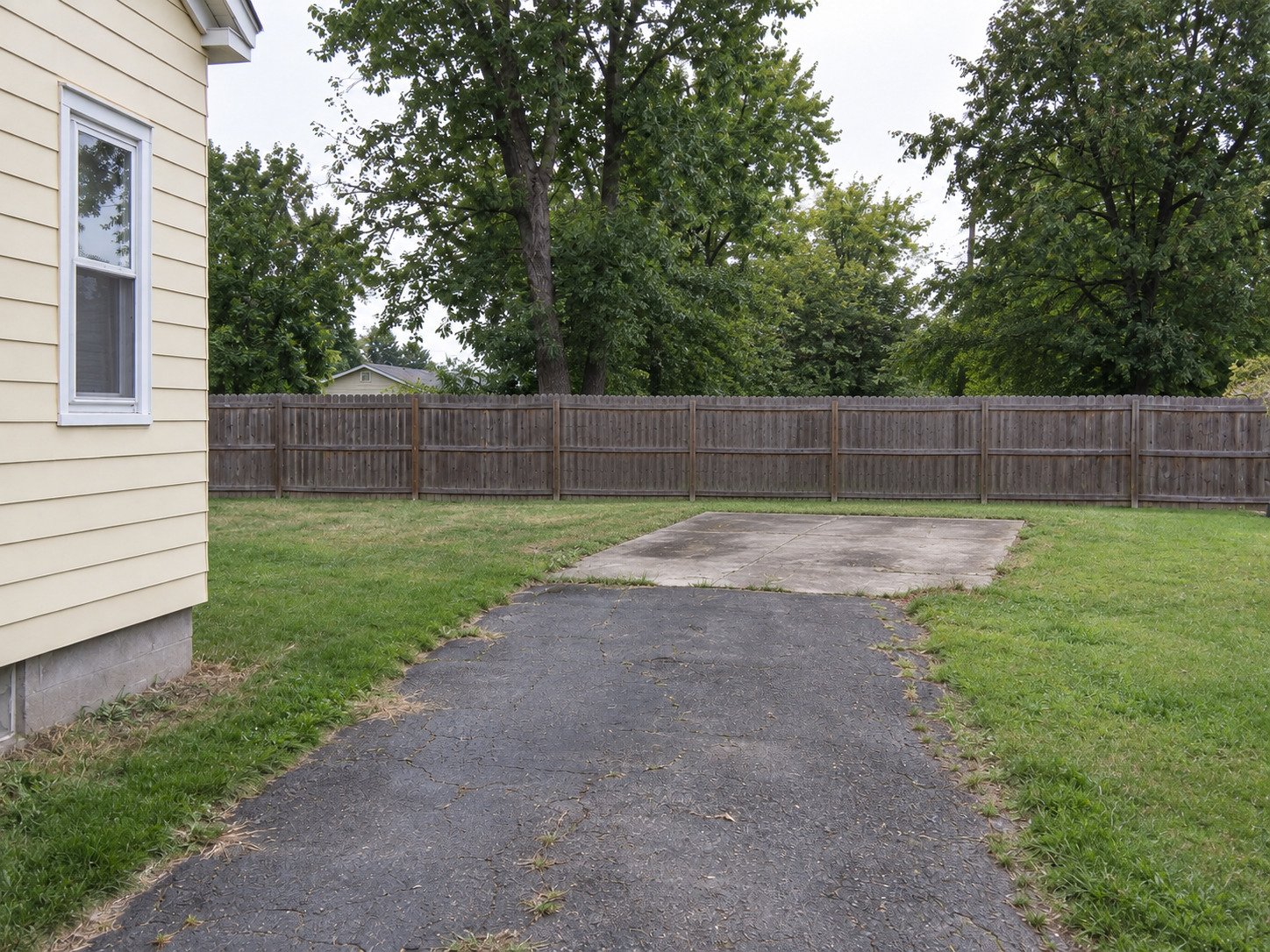 Original garage slab and worn driveway after the block garage was removed.