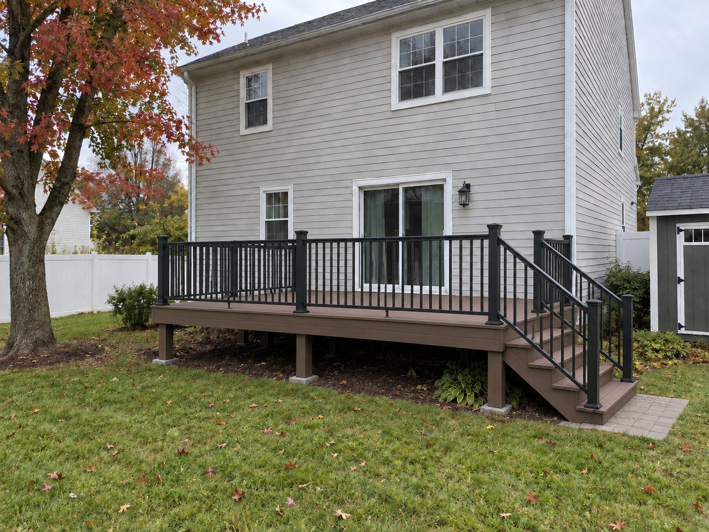 Empty brown composite deck with black rails and a grounded stair landing.
