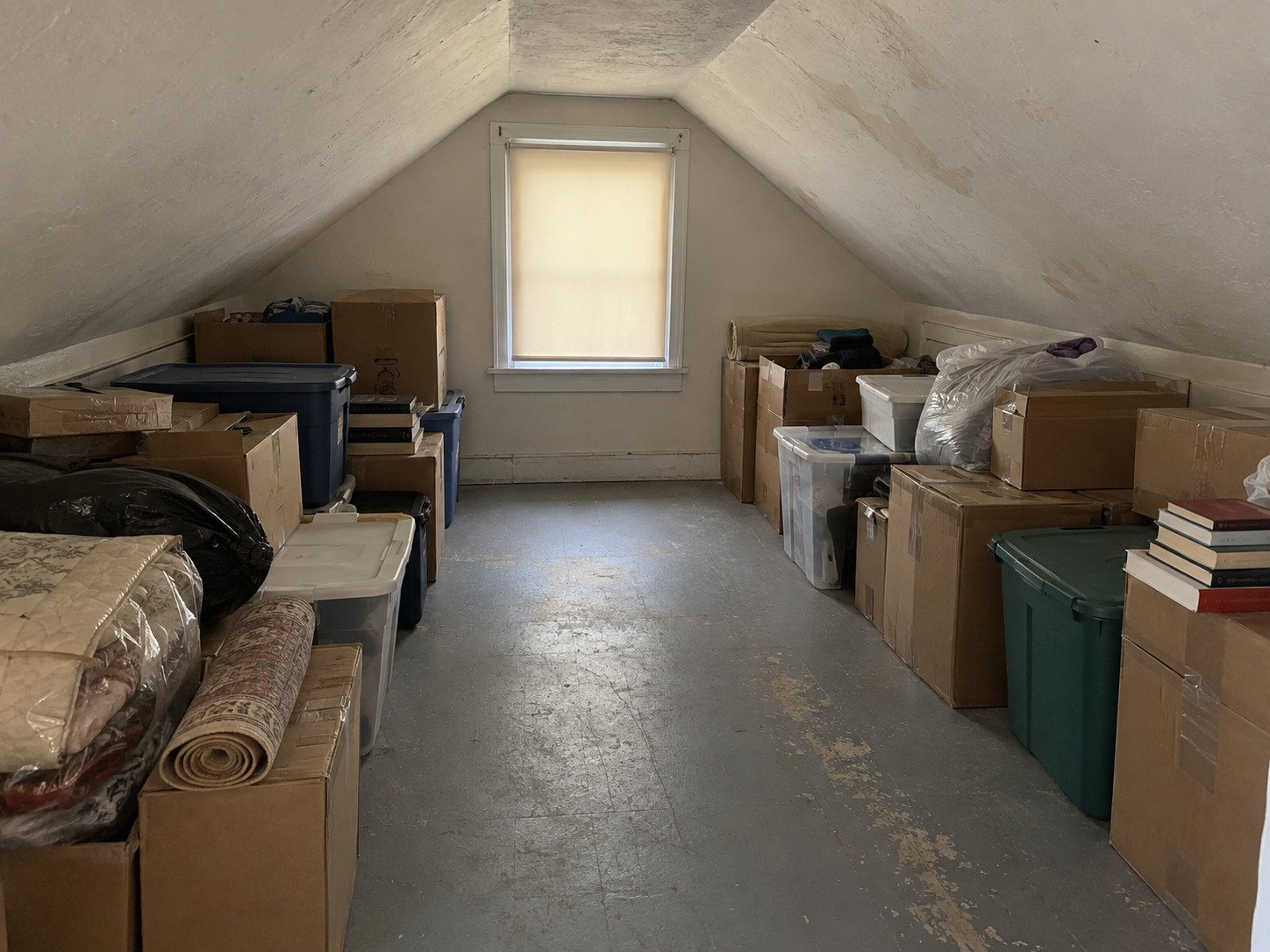 Attic filled with boxes, storage totes and bagged belongings before an estate cleanout.