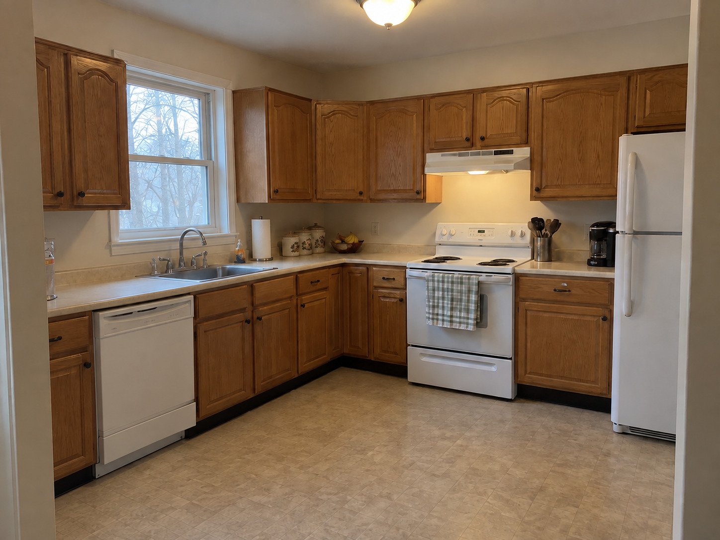 Older oak kitchen before remodeling, with dining furniture absent.