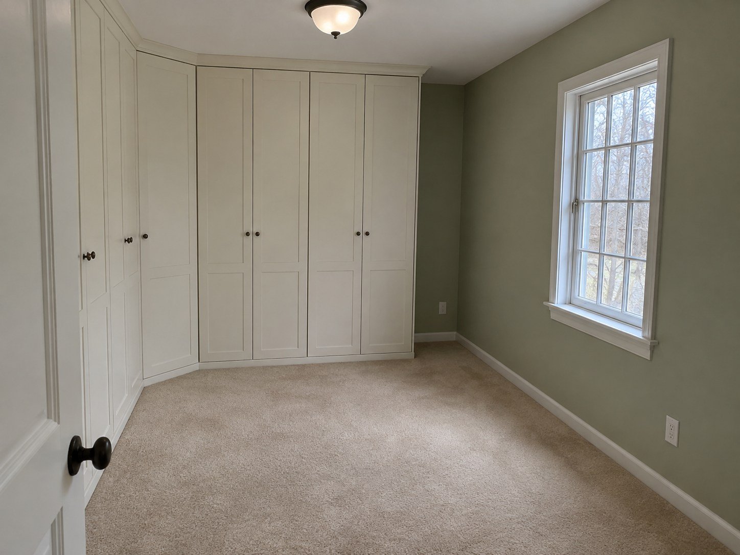 Built-in wardrobes and tan carpet in a small den before selective strip-out.