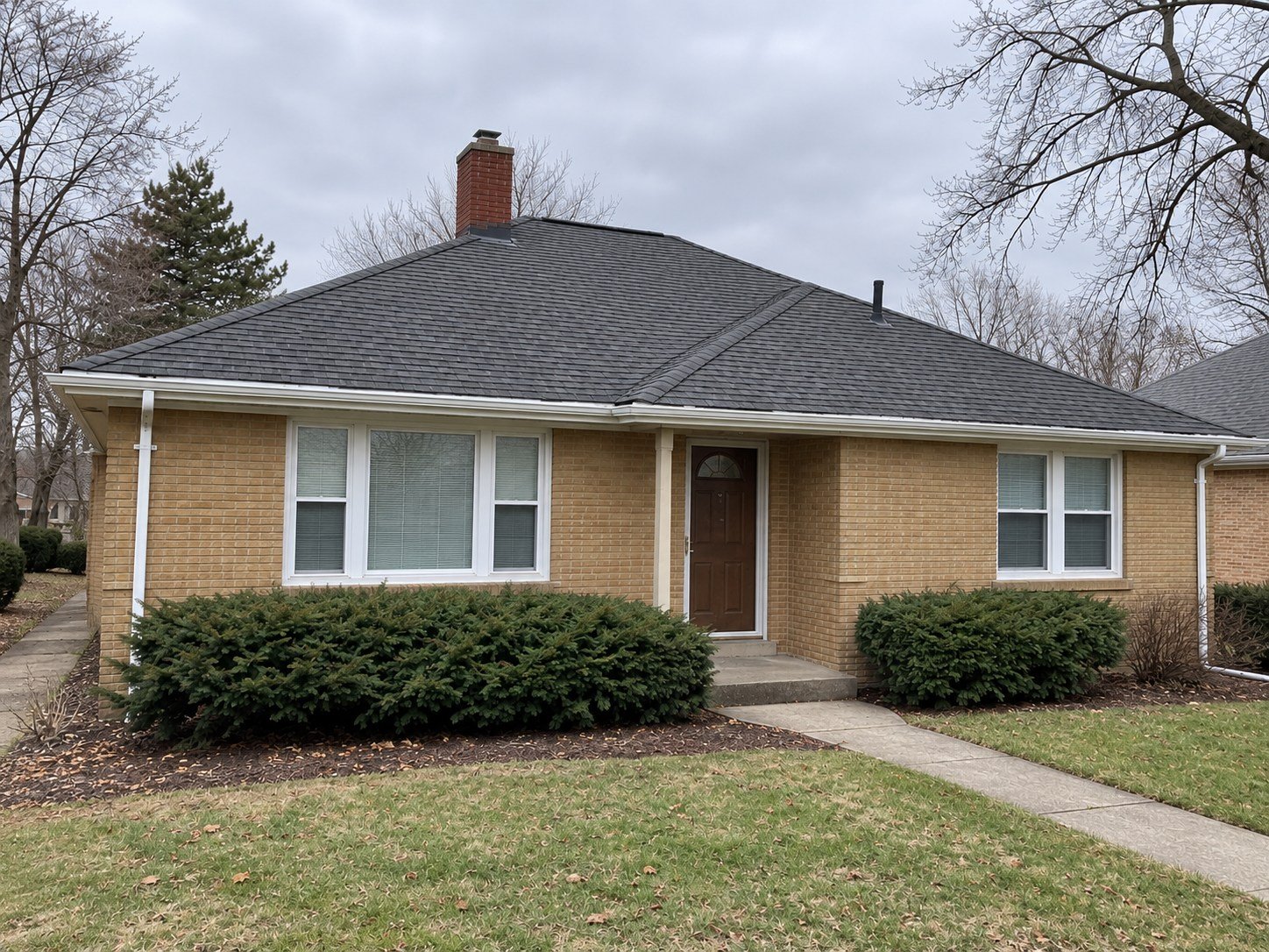 The same representative home with a completed charcoal shingle roof and original roof geometry retained.