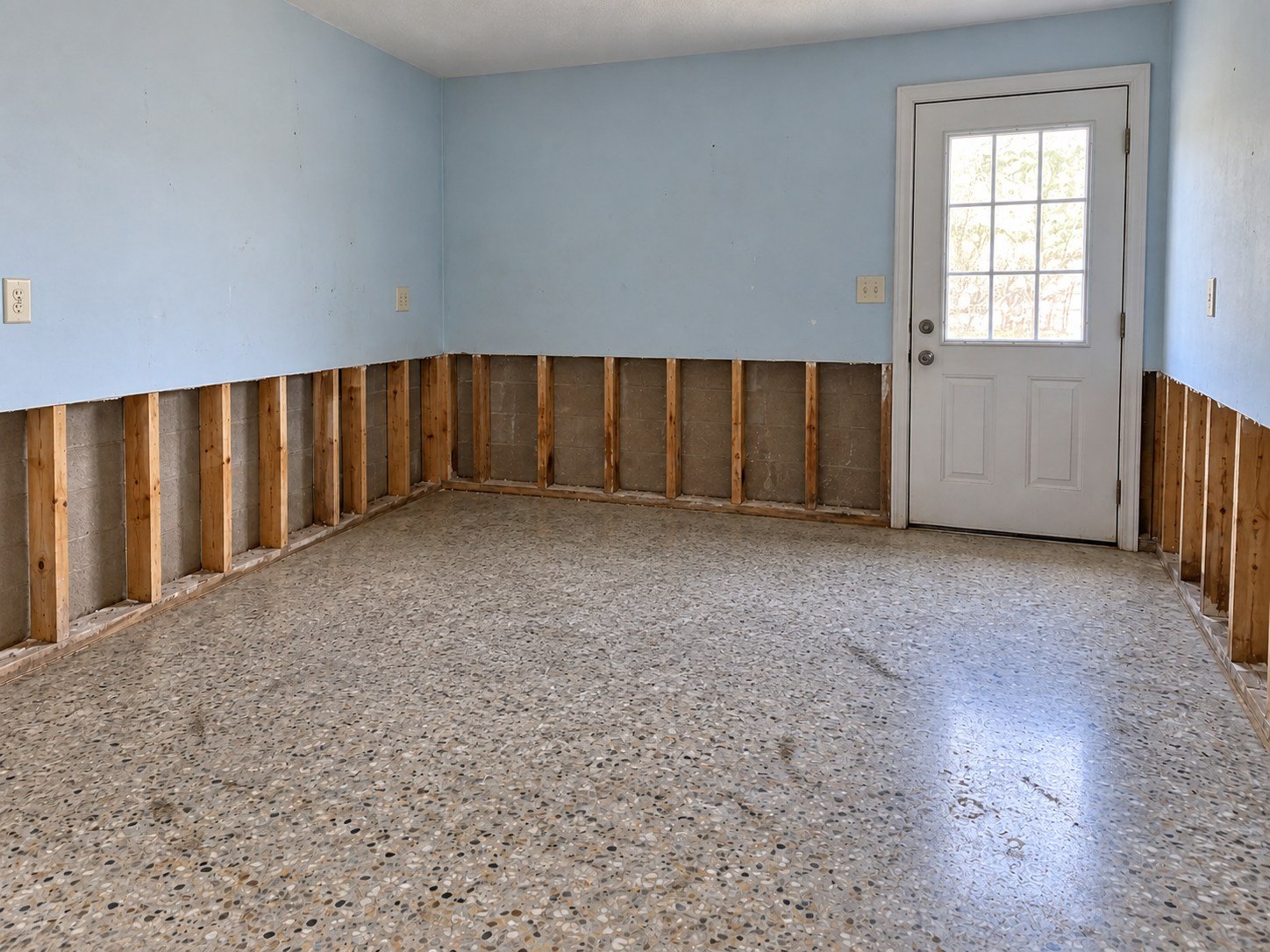 Room after debris removal, with existing flood-cut walls still open for the next trade.
