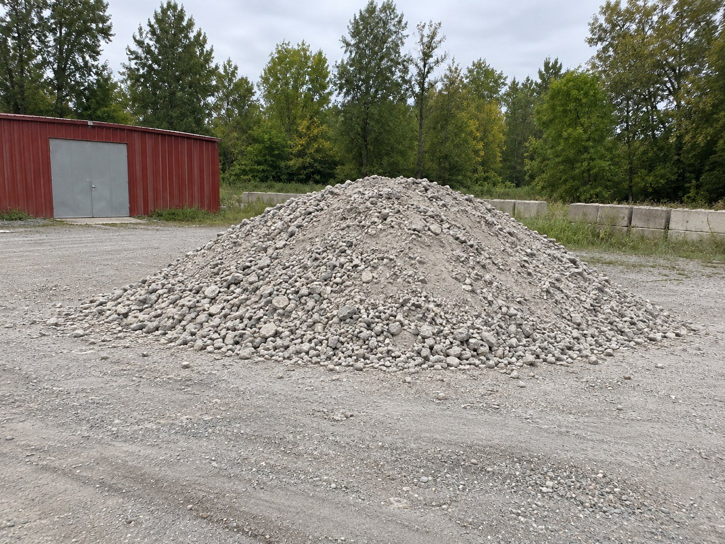 The same material processed into a smaller crushed-concrete stockpile at the same yard.