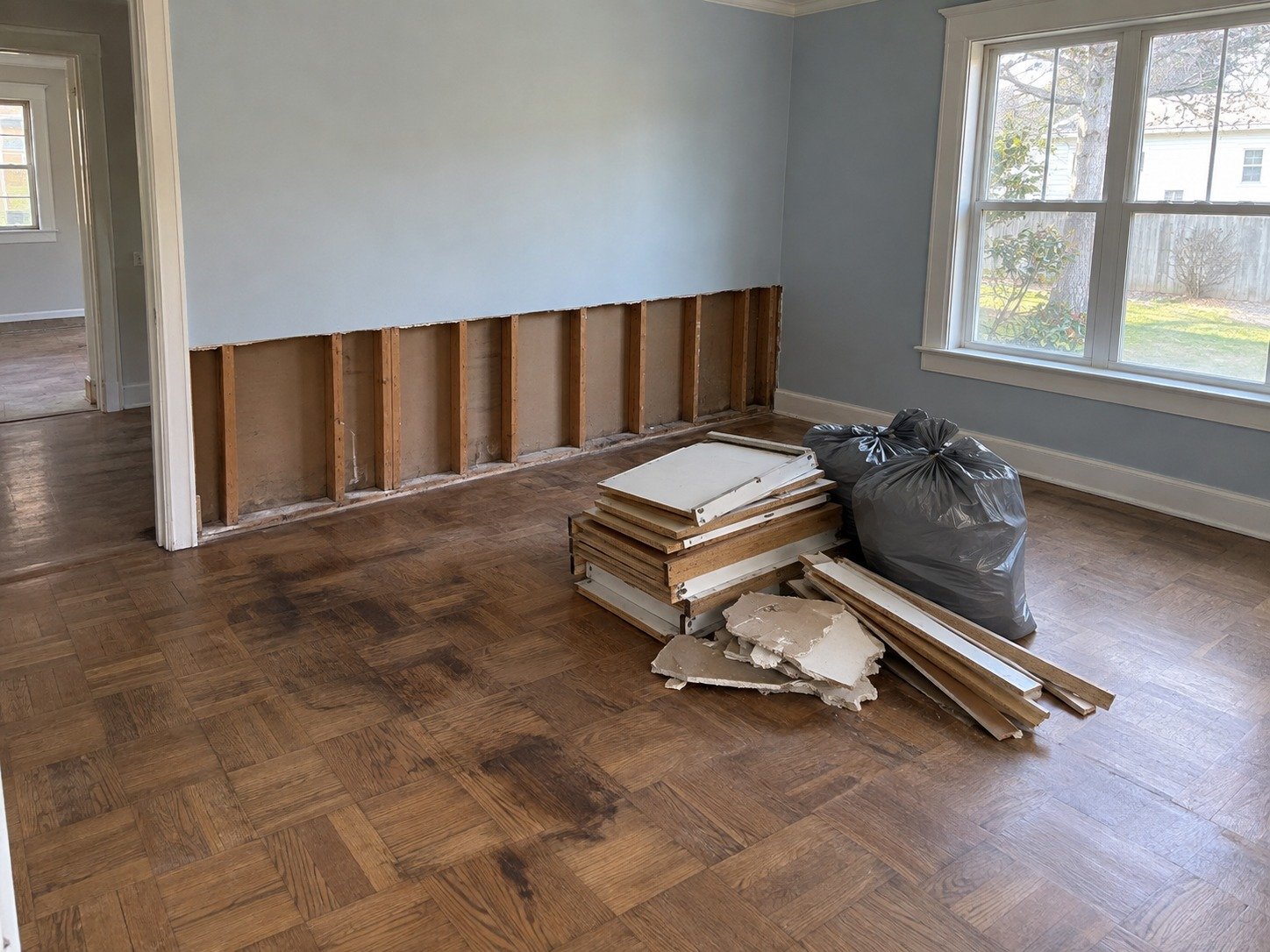 Water-damaged room with staged removed materials before debris hauling.
