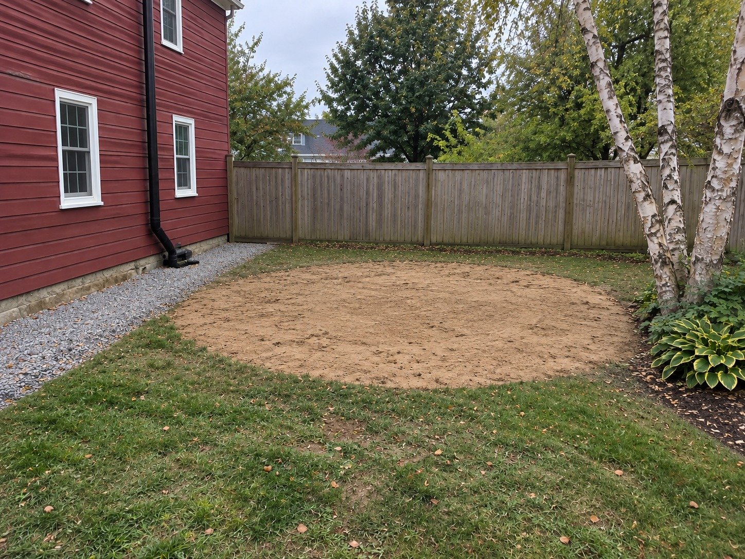 The same side yard with the pool removed and its footprint leveled.