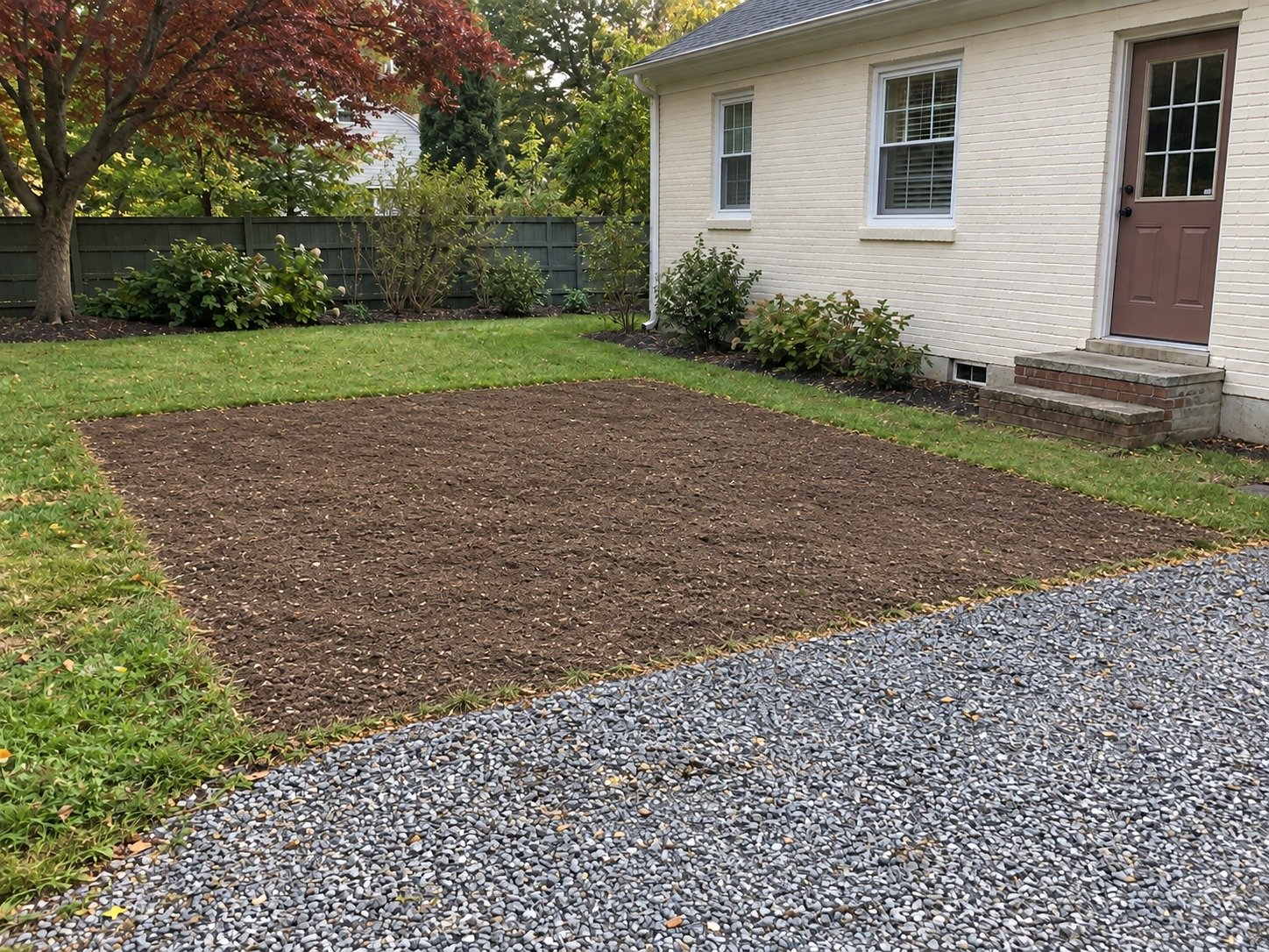 The same side-drive area after concrete pad removal and grading.