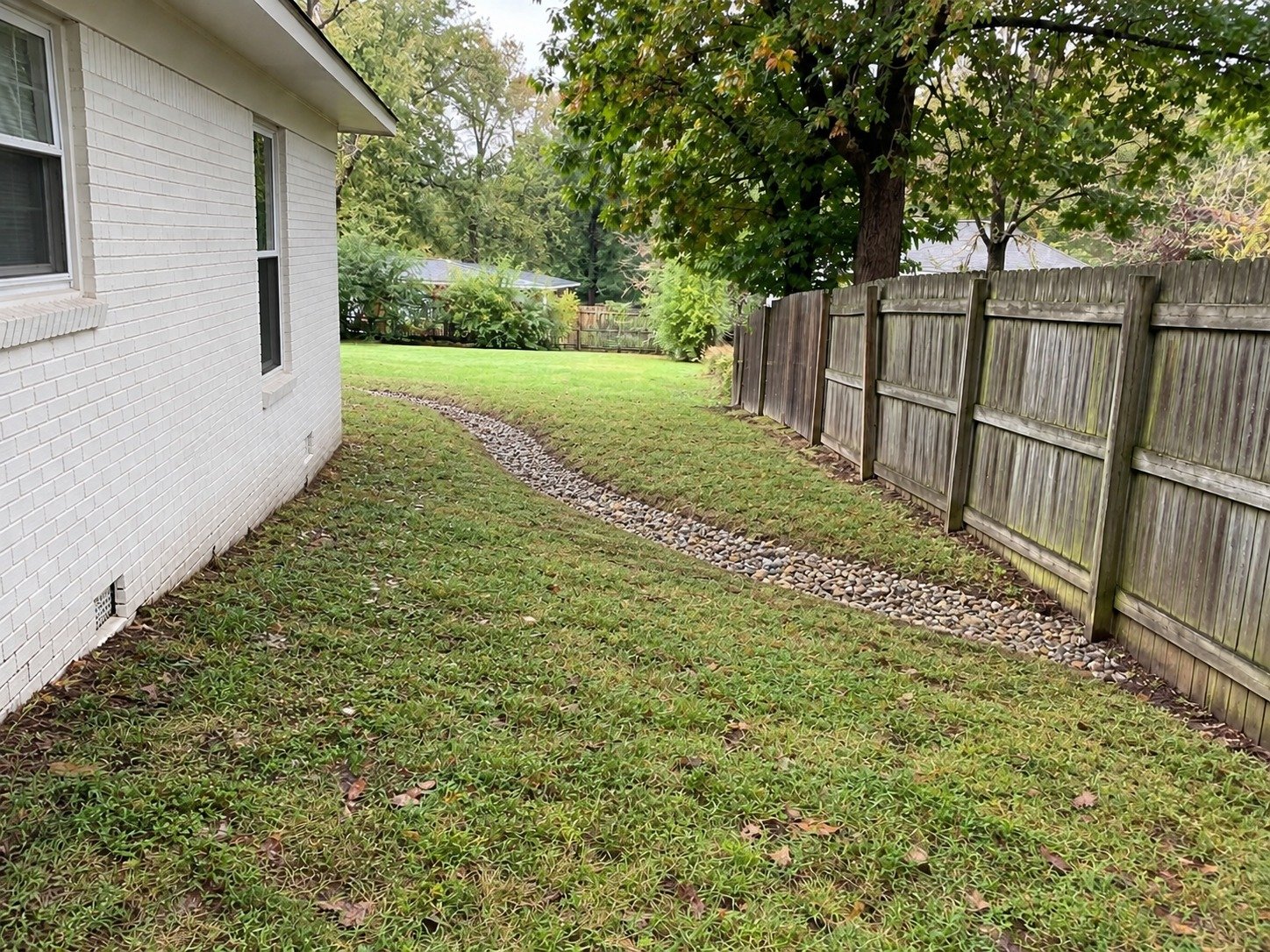 The same side yard with a shallow finished swale following the natural grade.