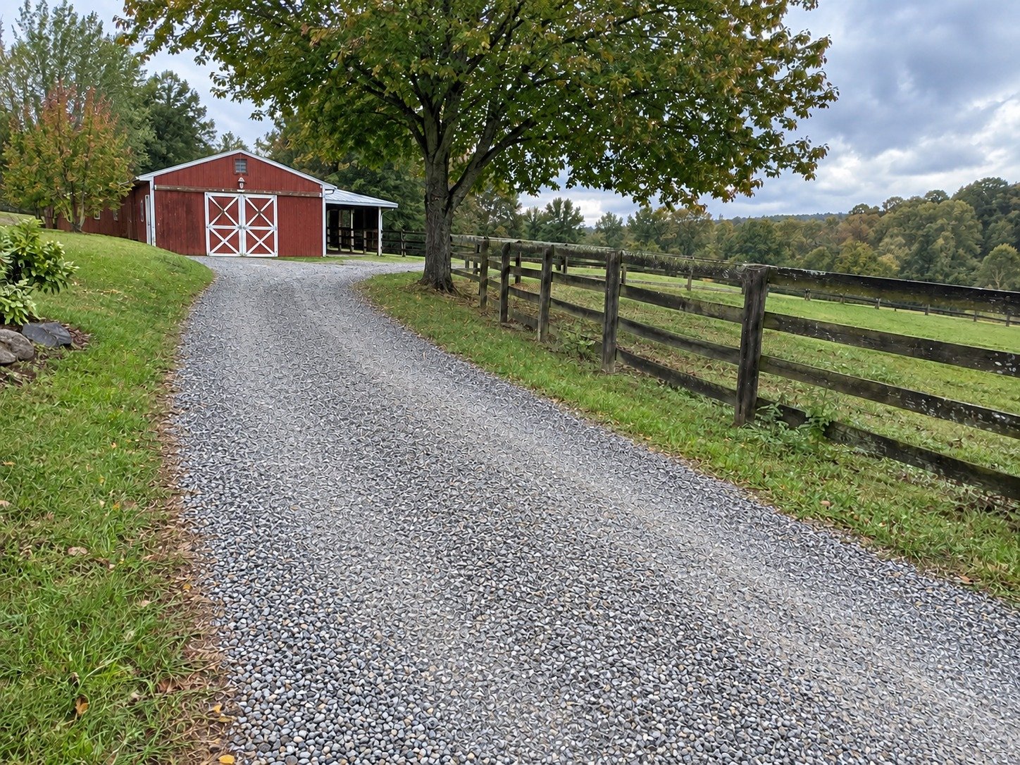 The same barn driveway after gravel grading restores a continuous usable surface.