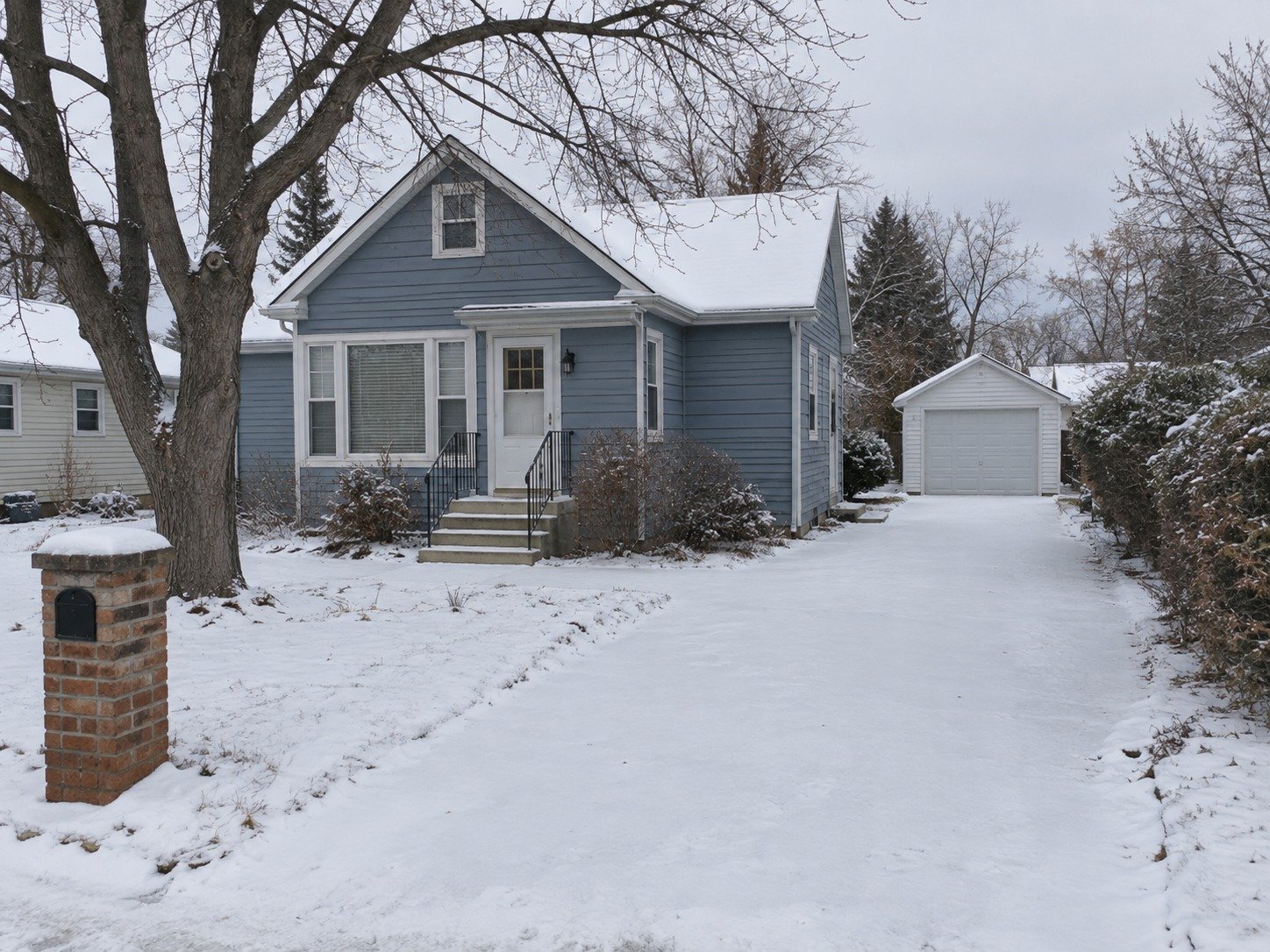 Snow-covered cottage driveway and entrance walk before clearing.