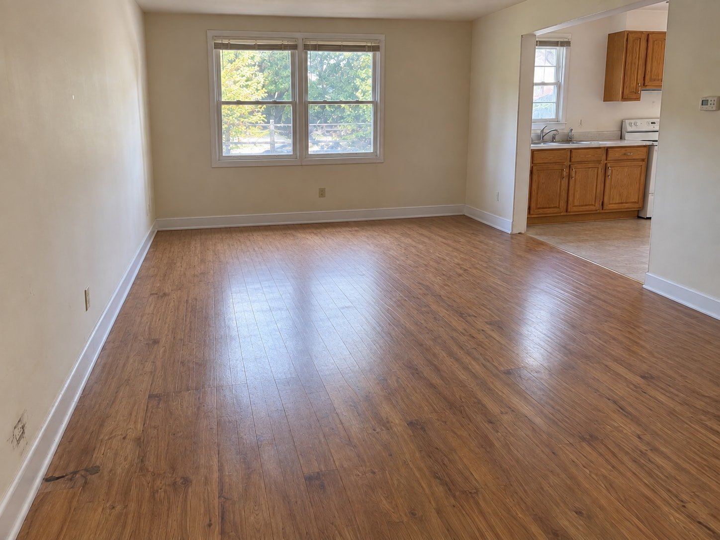 The same representative rental room after contents removal, with existing kitchen fixtures and surface wear retained.