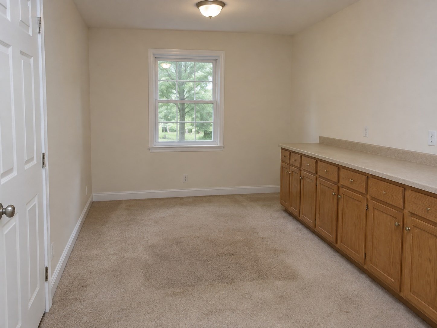Dated home office with carpet and built-in storage cabinets before selective strip-out.