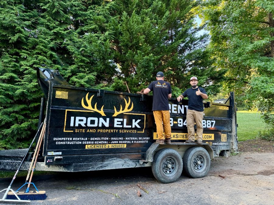Crew members beside a work truck and trailer.