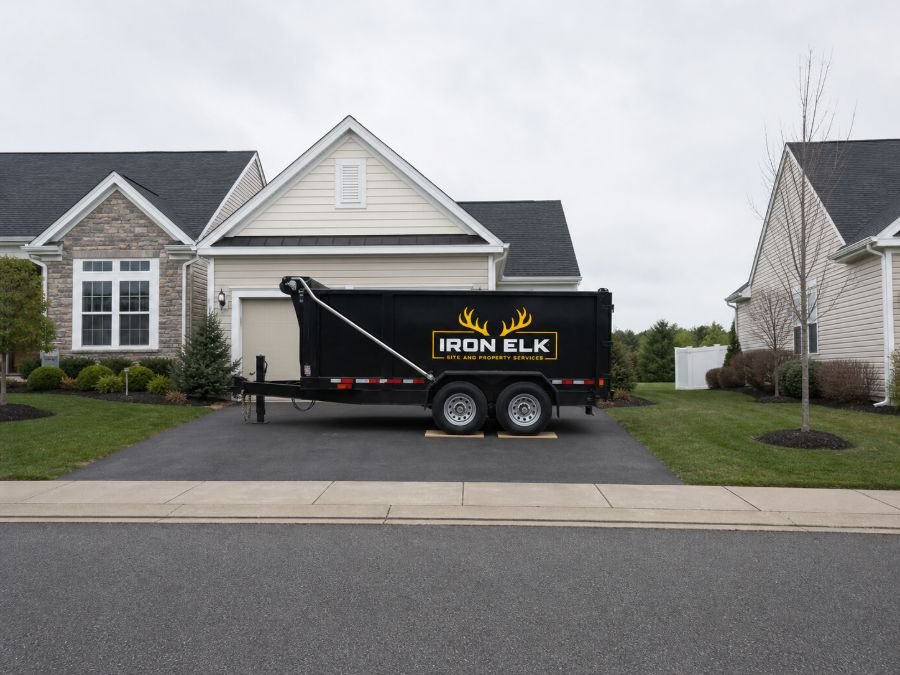 A trailer parked along a residential street in front of a house.