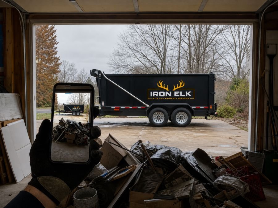 A phone framing a garage junk pile, the trailer visible outside the door.