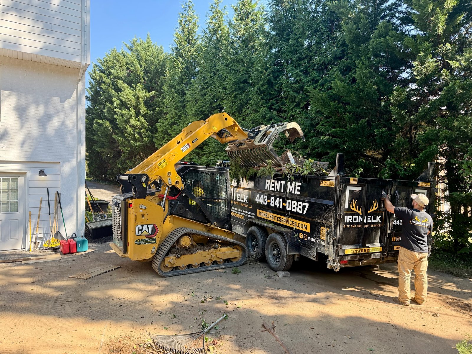A skid steer pushing brush into a pile.
