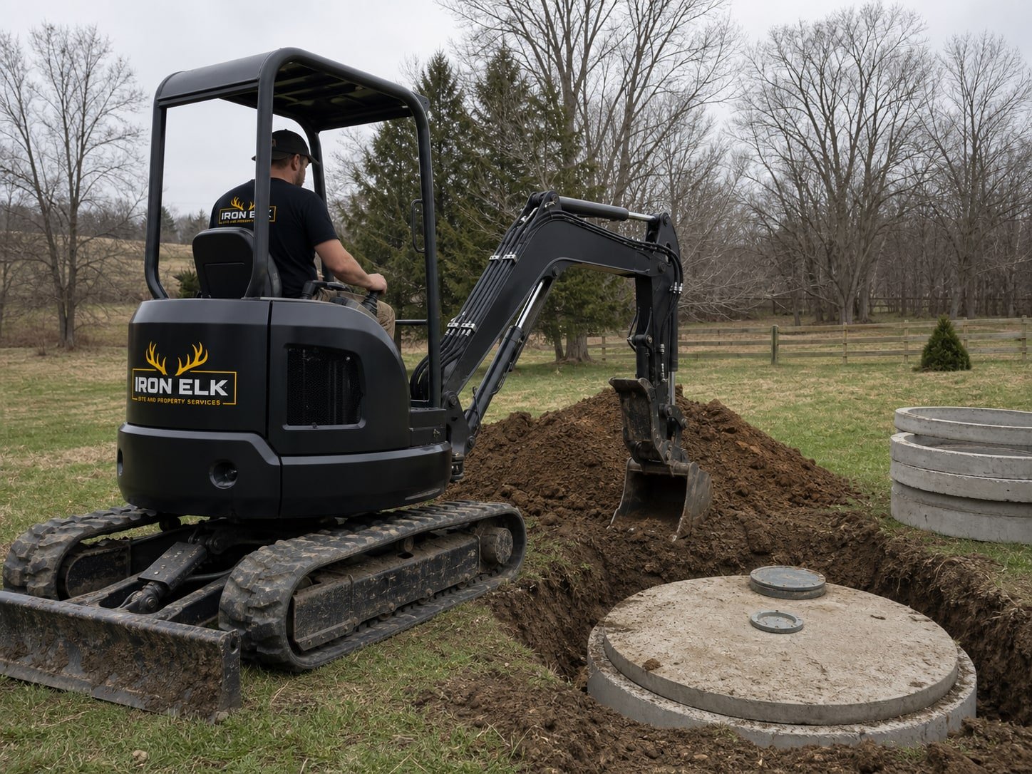An excavator working beside an exposed septic tank.