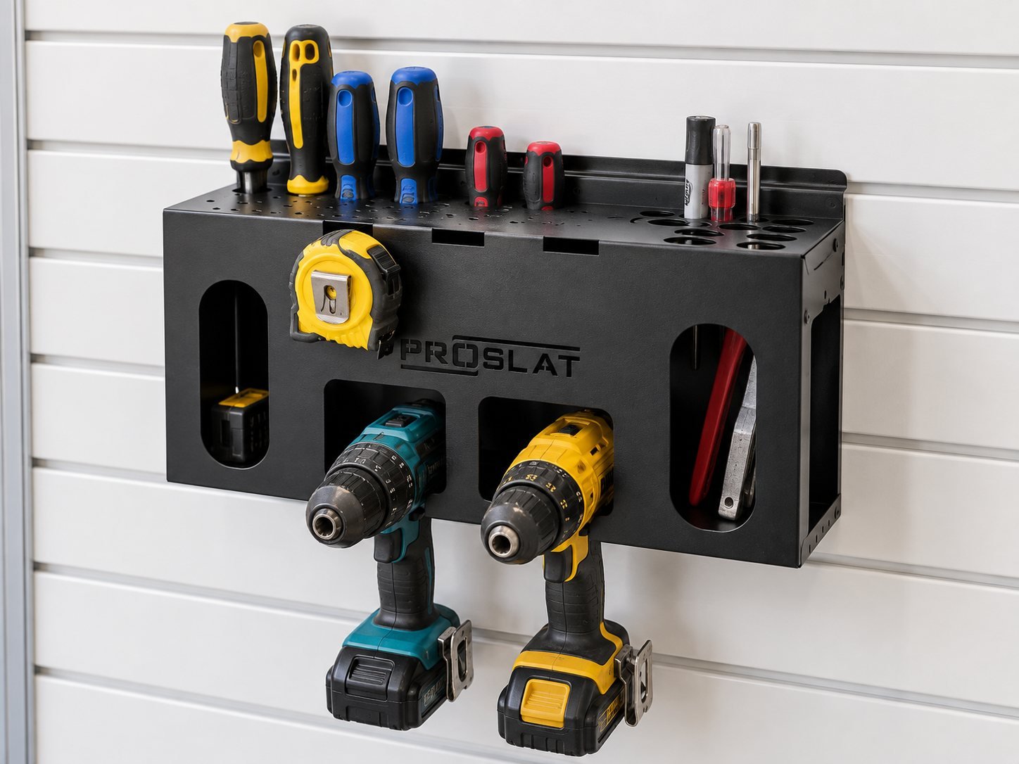 Example tool organizer on white slatwall: a black metal organizer holding screwdrivers, a tape measure, two cordless drills and hand tools.